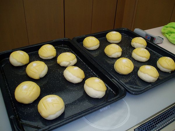 2つの天板の上に並んだ焼く前のメロンパンの写真